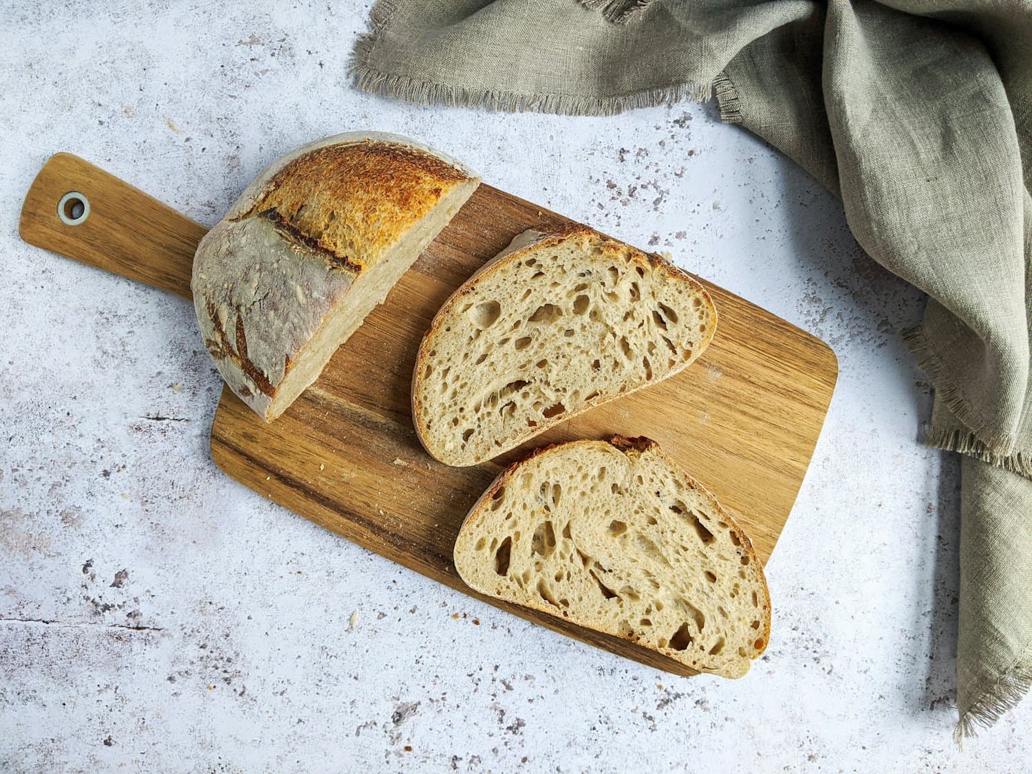 A sliced sourdough loaf showing an open, airy crumb